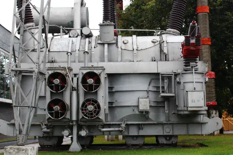 A large metal machine sitting on top of grass.